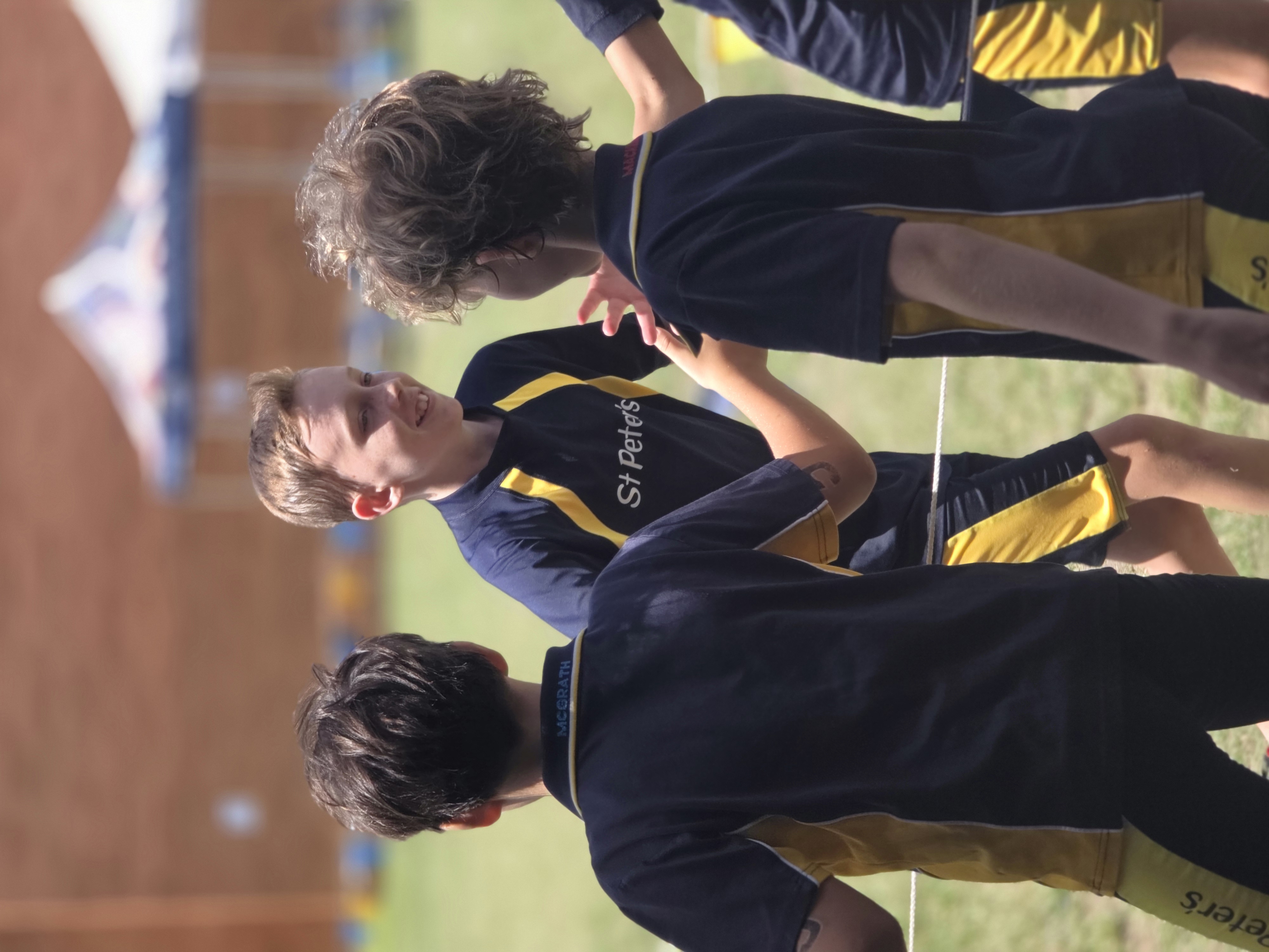 Students in school uniforms standing together on a sports field